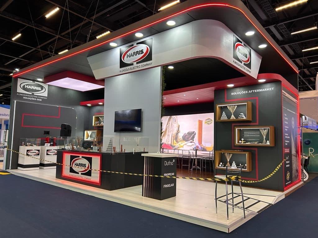 Stand da Harris, a Lincoln Electric Company, com iluminação vermelha e displays de componentes